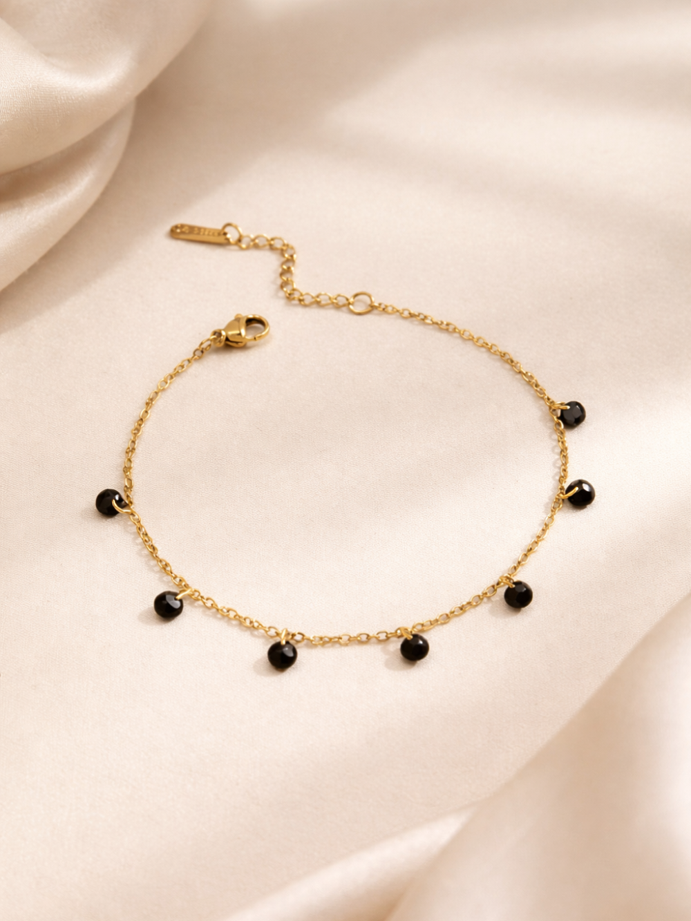 Gold bracelet with black beads