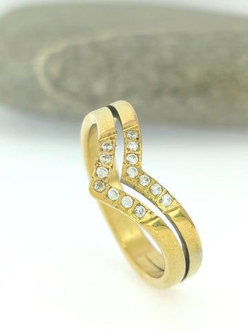 Gold ring with embedded diamonds on a neutral background