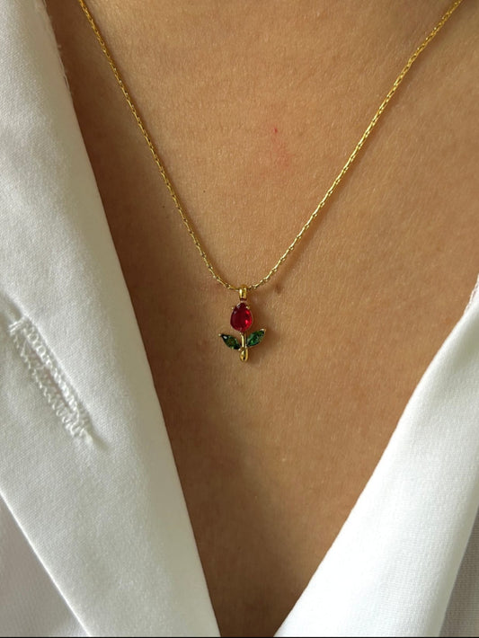 Gold necklace with a red and green pendant 