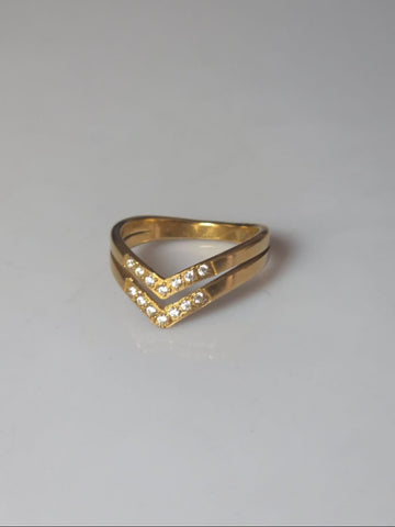 Gold ring with a V-shaped design on a gray background